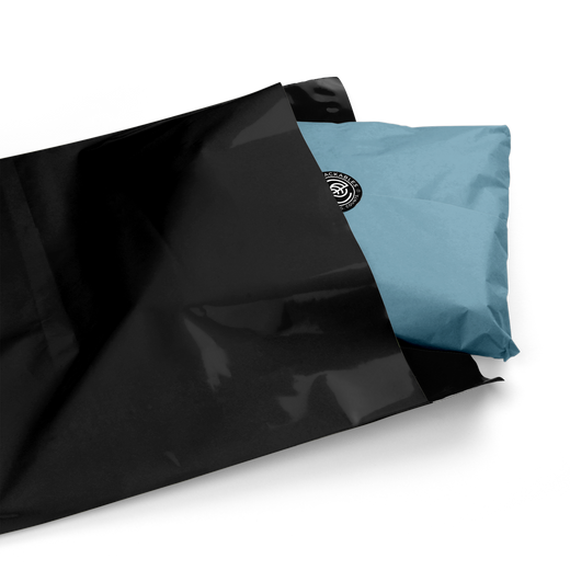 Blue package with EcoPackables logo sitting half out of a black polymailer